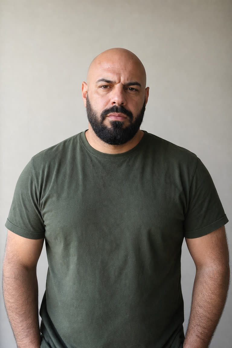 Input photo for the Crazy Frog AI example (chaser): a bald man with a black beard in an olive T-shirt (AI-generated sample person)